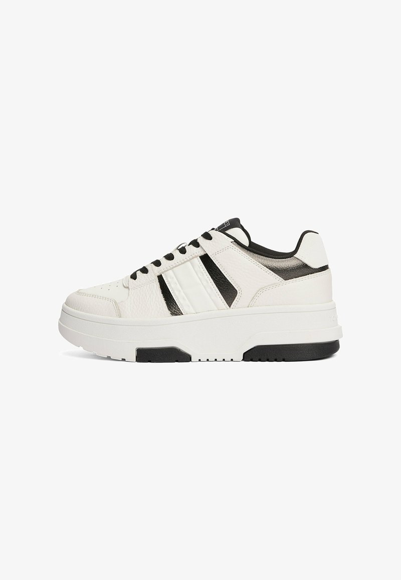 Sneaker basse in pelle bianca con dettagli neri, superficie texturizzata, strisce laterali bianche, punta rotonda e una spessa suola in gomma bianca e nera.