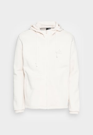 Sweat à capuche blanc zippé intégral avec cordons de serrage, poches latérales, manches longues et logo discret Adidas sur la poitrine gauche.