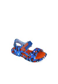 Sandalia de patrón azul y rojo con una correa de velcro, diseño de punta abierta y suela texturizada. Fabricada con material liviano y flexible.