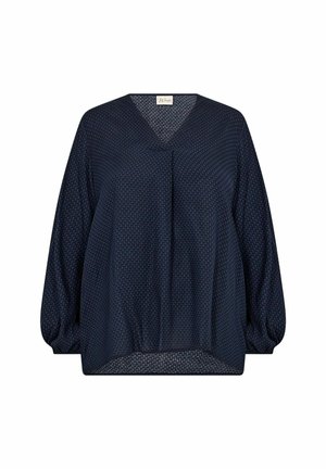 Blouse bleu marine avec un col en V, des manches bouffantes longues et un motif texturé. L'ourlet inférieur est légèrement arrondi pour un ajustement ample.