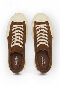 Braune Wildleder-Sneaker mit cremfarbigen Gummisohlen und runder Zehenform. Ausgestattet mit beigen Schnürsenkeln und silbernen Ösen. Innen mit "SUPERGA ARTIFACT" gekennzeichnet.