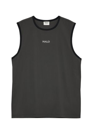 Athletic man standing, wearing a sleeveless black top, black layered shorts with gray inner layer, white socks, and gray running shoes.