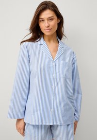 Blå og hvid stribet pyjamas sæt med en knap-til skjorte med lomme og lange ærmer, parret med matchende shorts. Blød stoftekstur.