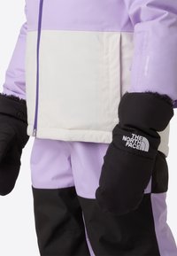 Purple and white insulated jacket with a contrasting black bottom, featuring a front zipper and texture-rich mittens with logo detailing.