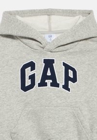 Γκρι βαμβακερό φούτερ με κουκούλα, με εφαρμογή "GAP" σε ναυτικό μπλε στο στήθος, διαθέτει τσέπη καγκουρό και επενδεδυμένη κουκούλα.