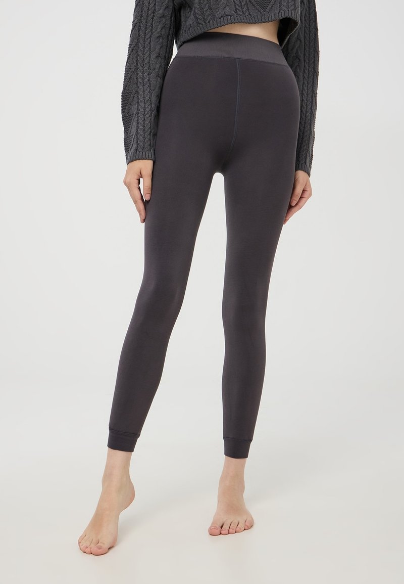 Ciemnoszare legginsy o gładkiej teksturze, z wysokim pasem i dopasowanym krojem. Rękawy przy kostkach są marszczone. Idealne do codziennego użytku lub do ćwiczeń.