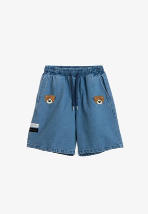 Pantalones cortos vaqueros con cintura elástica, cordón azul marino, dos bolsillos delanteros, parches con la cara de un osito de peluche en cada lado y una pequeña etiqueta en la pierna izquierda.
