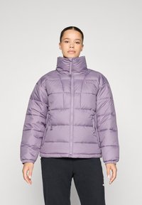 Polstret jakke i lys lilla, med høy krage, glidelås lukking og elastiske mansjetter. Designet inkluderer vertikale quiltede seksjoner og sidelommer.