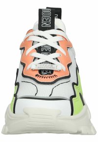 Sneaker bianca in rete con accenti neri, dettagli vivaci in arancione e verde, suola spessa e lacci prominenti, caratterizzata da un'etichetta con logo metallico.