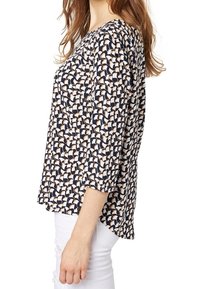 Top blu navy con un motivo geometrico in crema e beige. Presenta maniche a tre quarti, un collo rotondo e una vestibilità comoda.