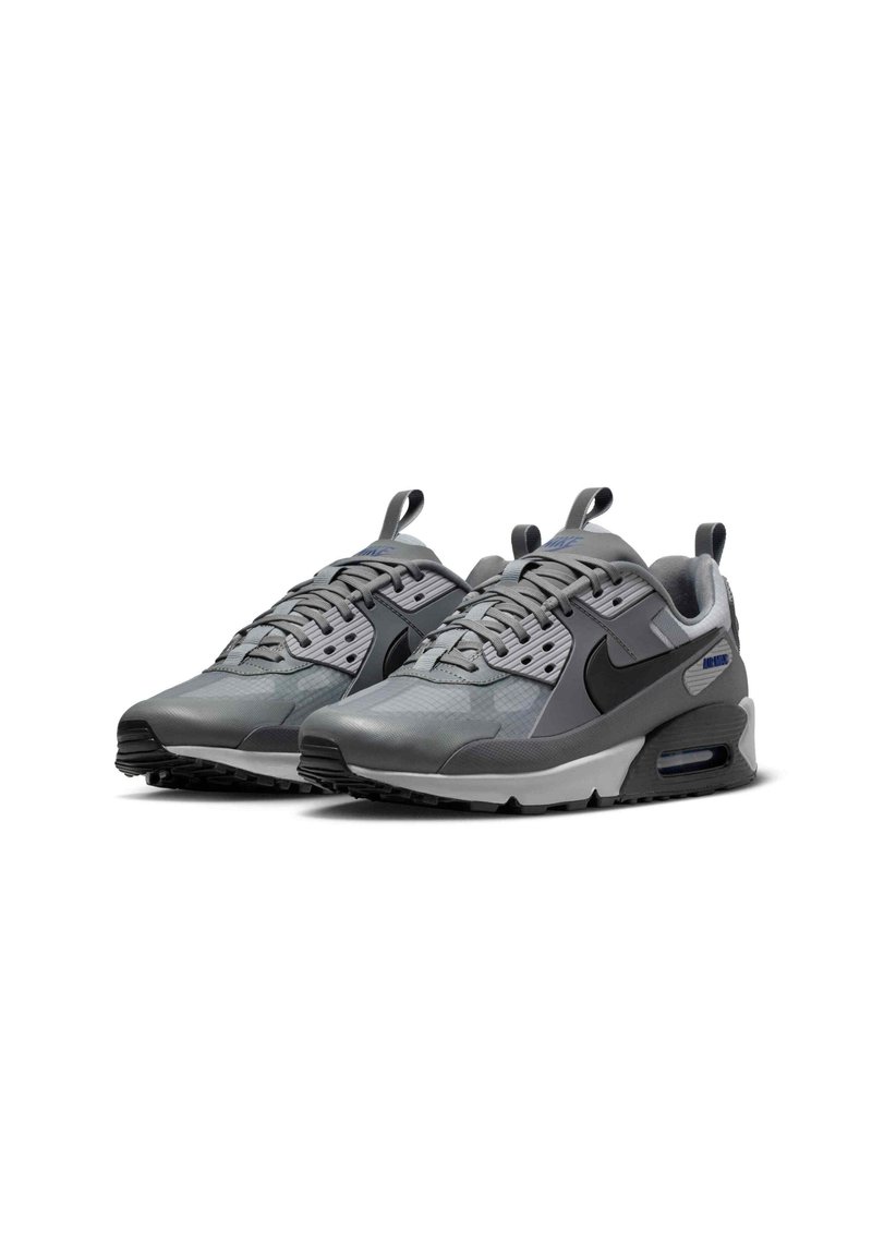 Paire de baskets Nike Air Max grises avec logos Swoosh noirs, tige en mesh et synthétique, et amorti Air visible dans la semelle.