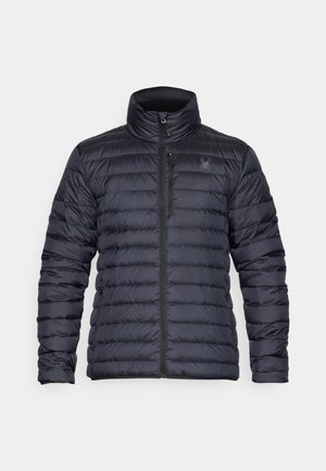 Puffer jacket in dark navy blue, featuring a zip front, high collar, and horizontal quilting. Includes side pockets and a subtle logo detail.