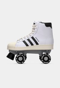 Λευκό ψηλό ρολλερ με μαύρες ρίγες, καουτσούκ σόλα και υφή στην μύτη. Διαθέτει μαύρους τροχούς με λευκά λογότυπα της Adidas.