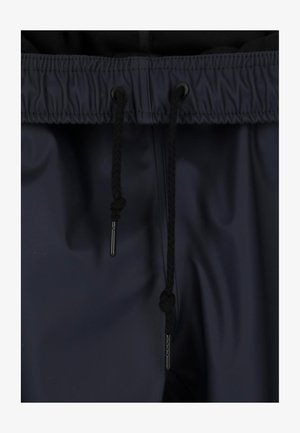 Navy blue jogger pants with a drawstring waist, featuring black braided drawcords and metal aglets, made of smooth, water-resistant material.