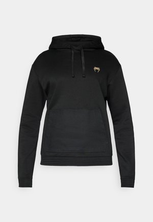 Black hooded sweatshirt with long sleeves, featuring a textured front pocket and a small gold logo on the chest. Smooth fabric texture.