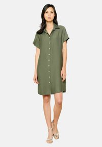 Vestito camicia a maniche corte verde khaki con chiusura a bottoni, colletto e vestibilità comoda, realizzato in tessuto morbido e leggero.