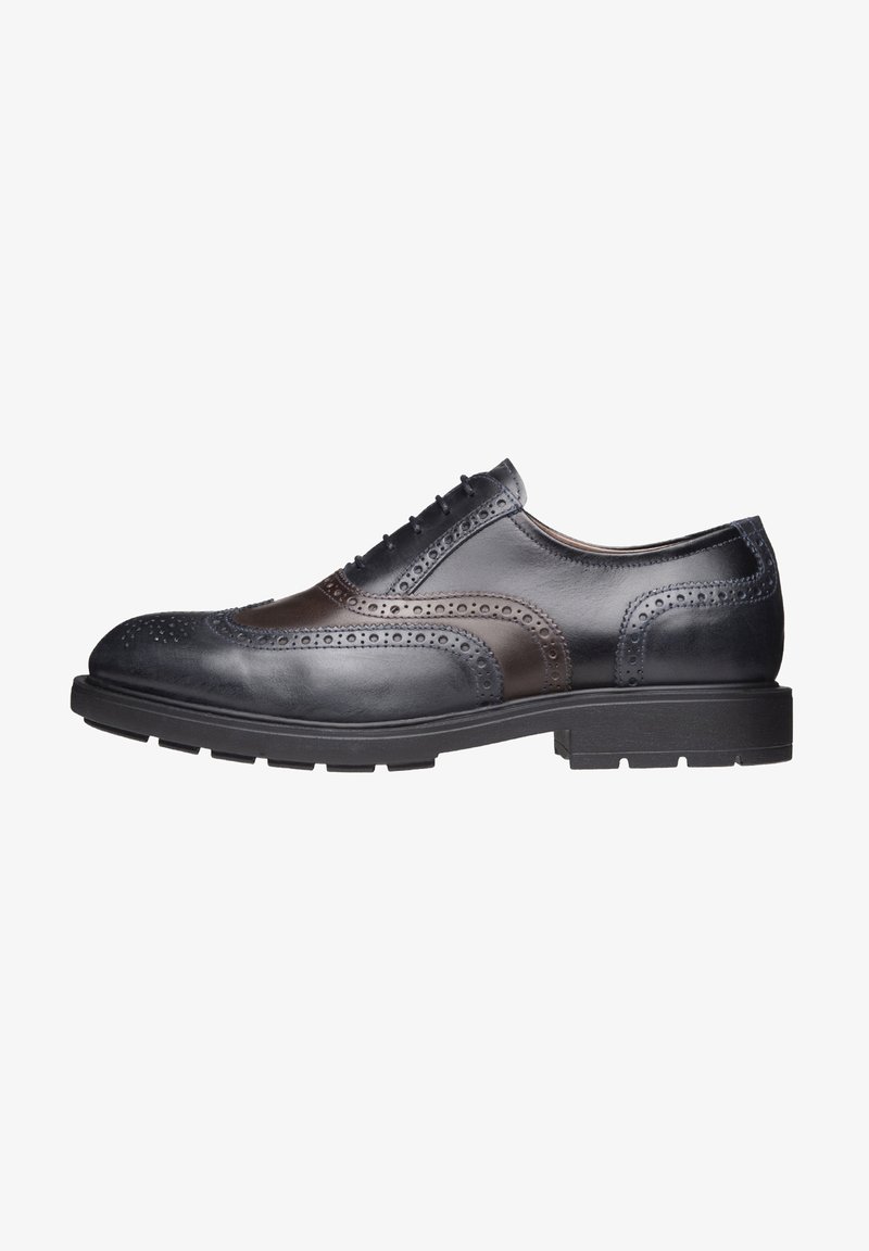 Derby brogue en cuir noir et marron foncé avec perforations en bout ailé et semelle en caoutchouc, vue de côté.