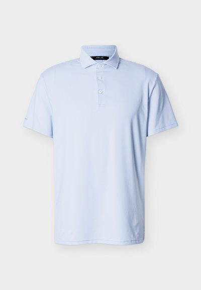 Ανοιχτό μπλε κοντομάνικο πόλο πουκάμισο με υφασμάτινη υφή, τρία λευκά κουμπιά και διπλωμένο γιακά σε απλό φόντο.