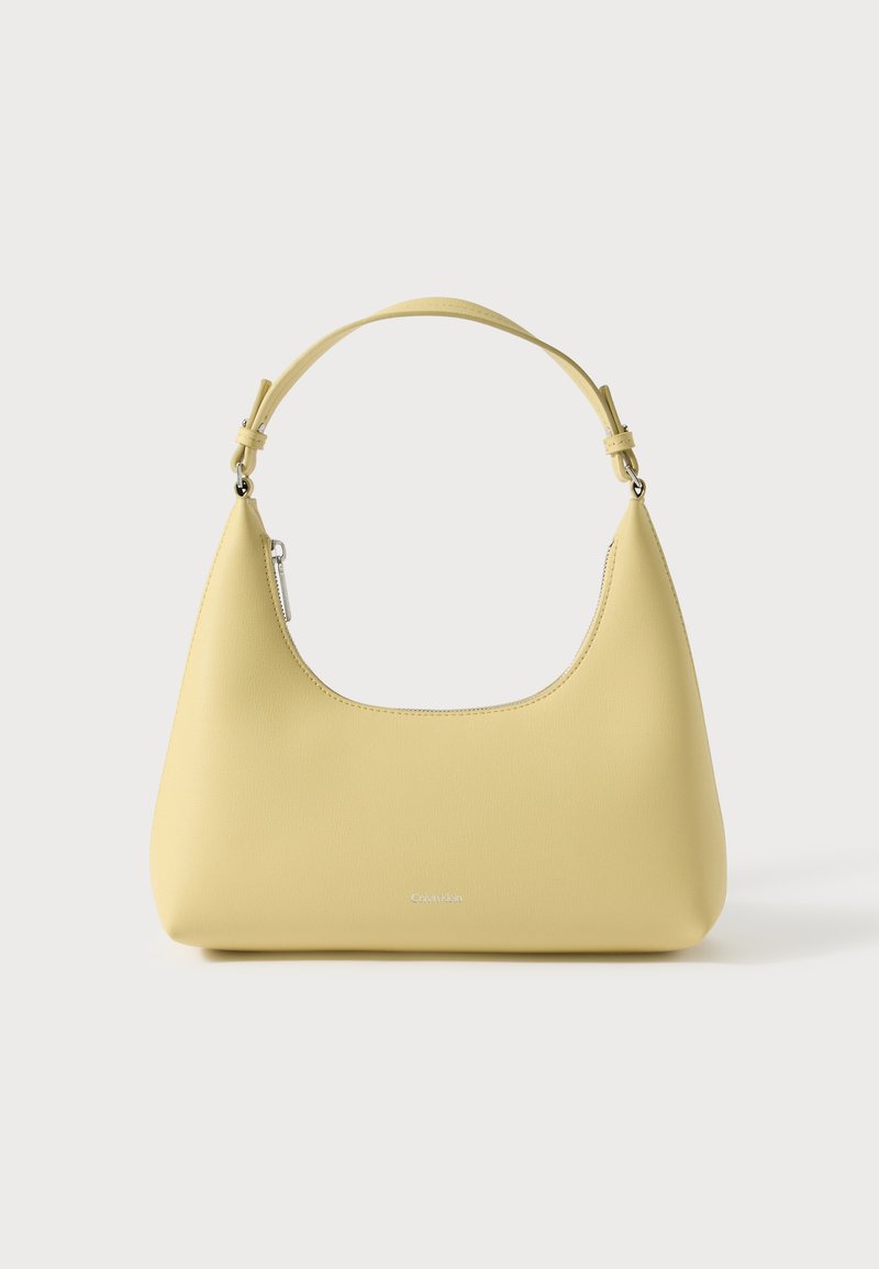 Yellow leather handbag with a curved silhouette, short adjustable strap, and a zippered compartment. Features a subtle logo on the front.