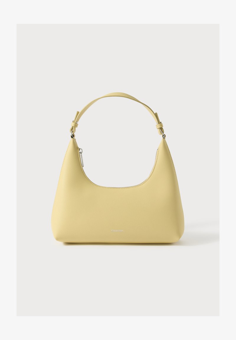 Yellow leather handbag with a curved silhouette, short adjustable strap, and a zippered compartment. Features a subtle logo on the front.