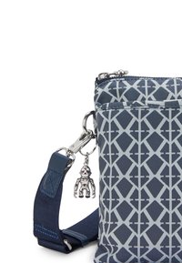 Borsa in nylon textured di colore blu navy con un motivo geometrico grigio chiaro. Dotata di chiusura a zip e un charm staccabile in argento. Spallaccio regolabile.