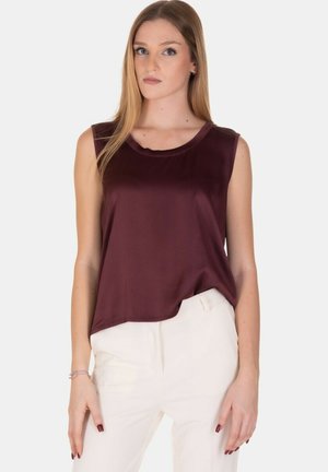 Top senza maniche color mogano in tessuto liscio con scollatura rotonda, abbinato a pantaloni bianchi. Design semplice, senza pattern o dettagli visibili.