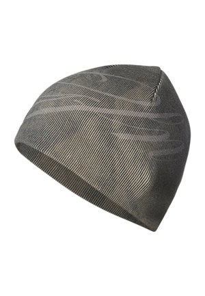 Hombre con un gorro de punto gris y una camiseta negra con un pequeño logo blanco en el pecho, mostrando el antebrazo tatuado.