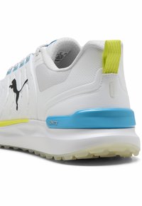 Άσπρο αθλητικό παπούτσι με υφαντή επιφάνεια, μπλε και νέον κίτρινες λεπτομέρειες και χοντρή σόλα με την ένδειξη "IGNITE." Διαθέτει σχέδιο με ραφές και θηλιά για τράβηγμα.