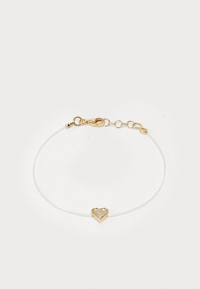 Bracelet avec un cordon fin blanc et un pendentif en forme de cœur en or orné de pierres scintillantes et d'une fermeture à fermoir.