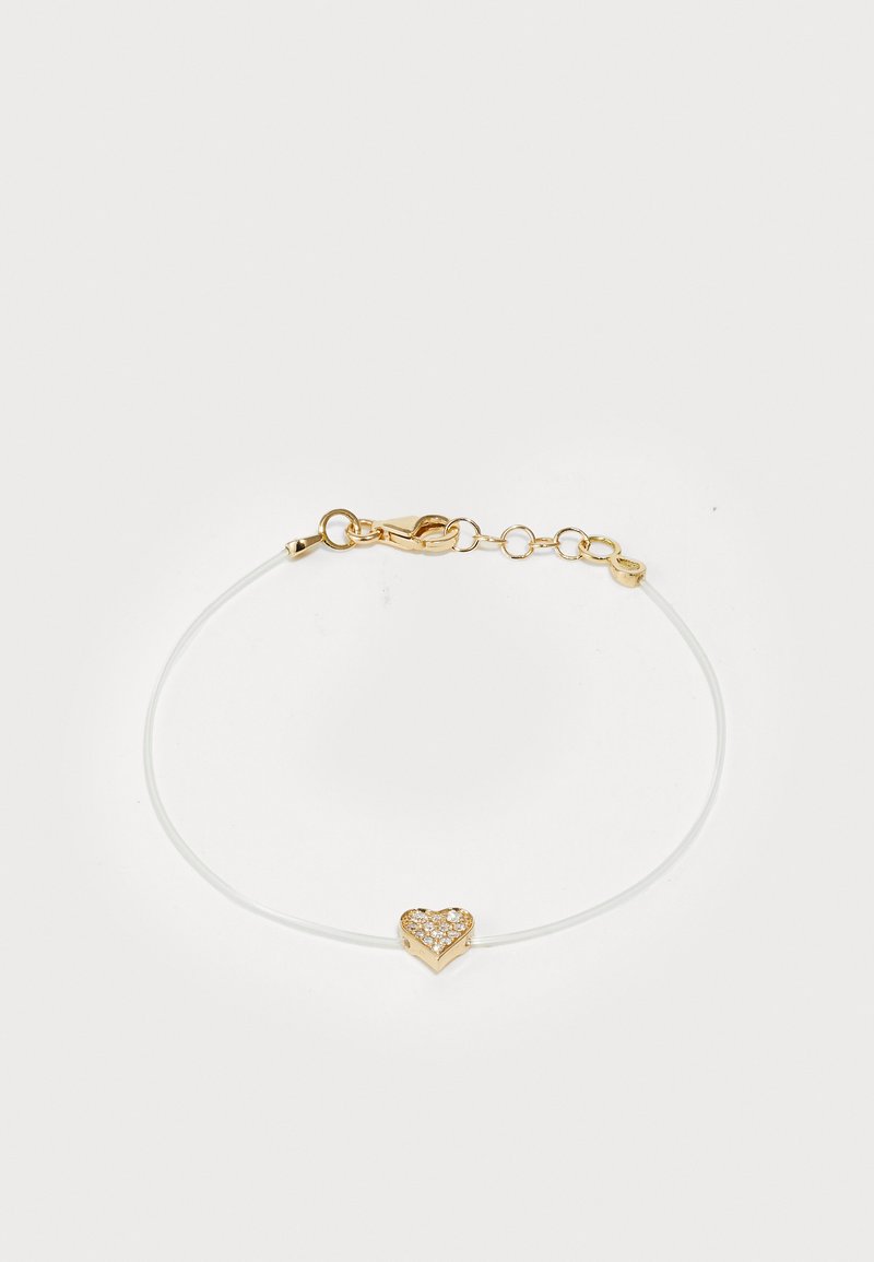 Rand koos valge, õhukese nööriga, millel on kuldne südamekujuline ripats, kaunistatud sädelevate kivitükkidega ja lukuga.