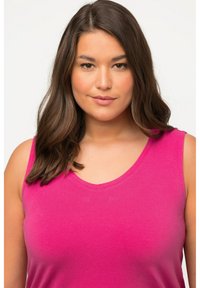 Fuchsia mouwloze tanktop met een ronde halslijn. Gemaakt van zachte stof, met een gladde textuur en een flatterende pasvorm.