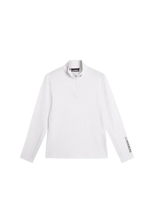Vit långärmad tröja med dragkedja i kragen, med en logo på vänster ärm. Tillverkad av ett mjukt, lätt tyg.