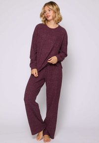 Conjunto de salón burdeos que incluye una blusa de manga larga y corte holgado, junto con pantalones de pierna ancha a juego, confeccionados en una suave tela texturizada.
