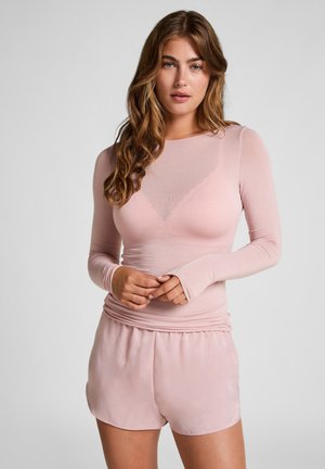 Light pink long-sleeve top in sheer material with a fitted design and crew neck, paired with soft pink shorts with an elastic waistband.