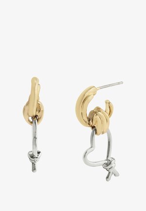 Boucles d'oreilles en or et argent en forme de banane avec un détail en forme de cœur, présentant une finition polie et des éléments texturés.