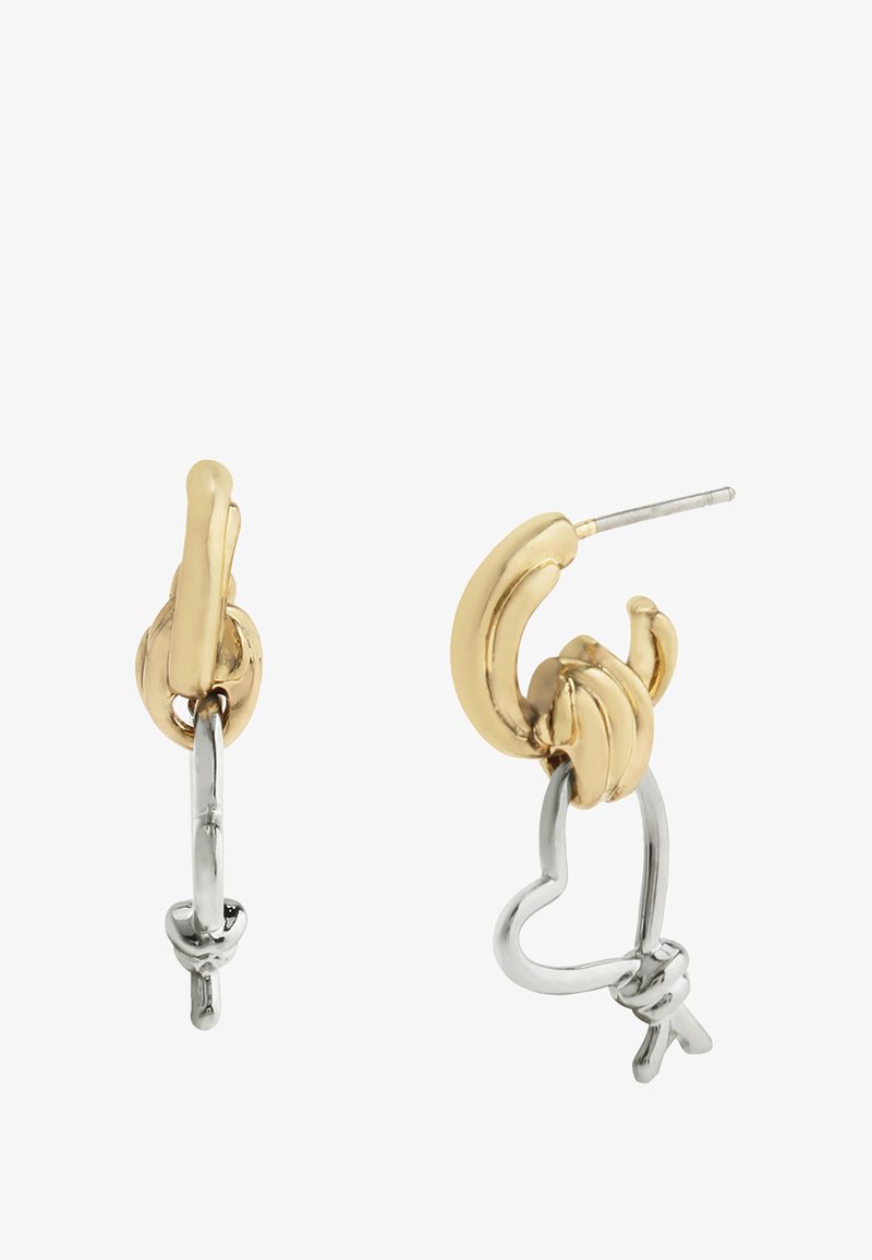 Guld- og sølvøreringe i form af en banan med hjerte detaljer, der har en poleret overflade og teksturerede elementer.