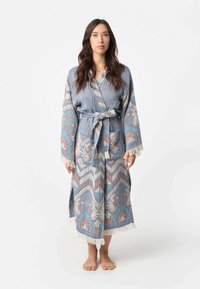 Lange robe in blauw en beige met geometrische patronen en franjes. Gemaakt van textuurstof, met een strakke taille en zakken.