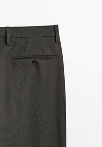 Pantaloni tailored grigio scuro con una tasca posteriore con dettaglio a bottone, texture del tessuto liscia e un cinturino elegante.