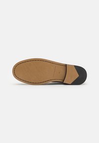 Semelle de chaussure en cuir marron avec une texture lisse, dotée d'un bout en caoutchouc noir et de coutures détaillées le long du bord. Taille 41.