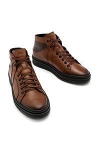 Brązowe skórzane sneakersy wysokie z czarnymi gumowymi podeszwami, charakteryzujące się gładką fakturą, sznurowanym zapięciem i subtelnym logo na języku.