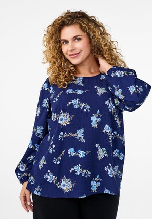 Marinebluse med blomsterprint i nuancer af blå, med ballonærmer, rund halsudskæring og tekstureret stof.