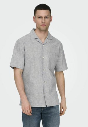 Chemise à manches courtes, boutonnée, à rayures verticales bleu et blanc. Dotée d'une poche poitrine et d'un col arrondi. Le tissu semble léger et texturé.