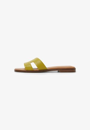 Yellow leather slide sandal with an open toe and two overlapping straps, featuring a flat brown sole with slight texture.