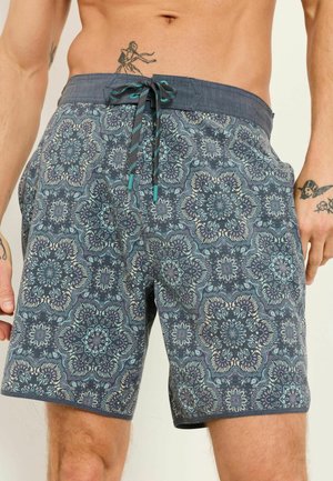 Shorts de bain pour hommes à motif avec des dessins floraux mandala bleus et beiges, et une ceinture bleu foncé avec un cordon de serrage.