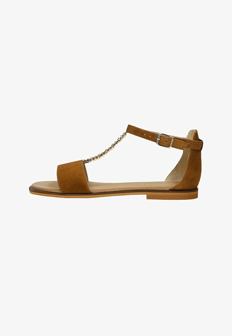 Sandale plate en daim marron avec bride à la cheville, détail chaîne dorée et fermeture à boucle sur fond blanc.
