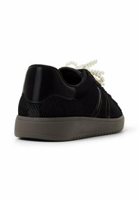 Czarne dziane sneakersy z teksturowanym wzorem, błyszczący czarny kaptur na piętę i kremowe sznurówki. Posiada szary gumowy bieżnik.