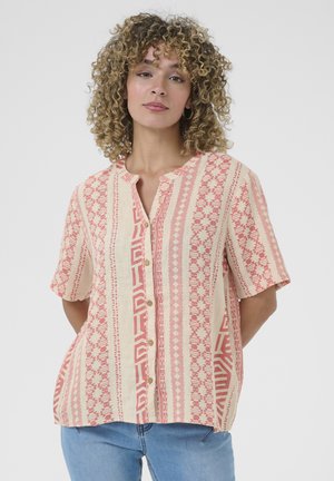 Camisa de manga corta, con botones, en color crema y coral, con patrones geométricos, cuello mao y un corte relajado, hecha de una tela ligera.