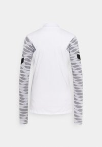 Langarmshirt mit einem weißen Körper und grauen gemusterten Ärmeln; verfügt über einen Kragen und schwarze Akzente an den Schultern. Glatte Textur.