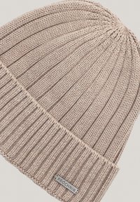 Dziergana czapka w miękkim beżu, z pionowym ryftowaniem i złożonym mankietem. Zawiera małą metalową metkę z nazwą marki "PROCHNIK."