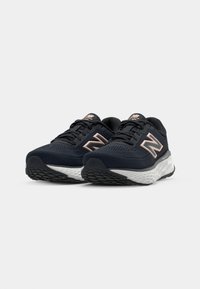 Dark navy running shoes with a mesh upper, featuring a light pink logo accent. Textured outsole and supportive cushioning design.